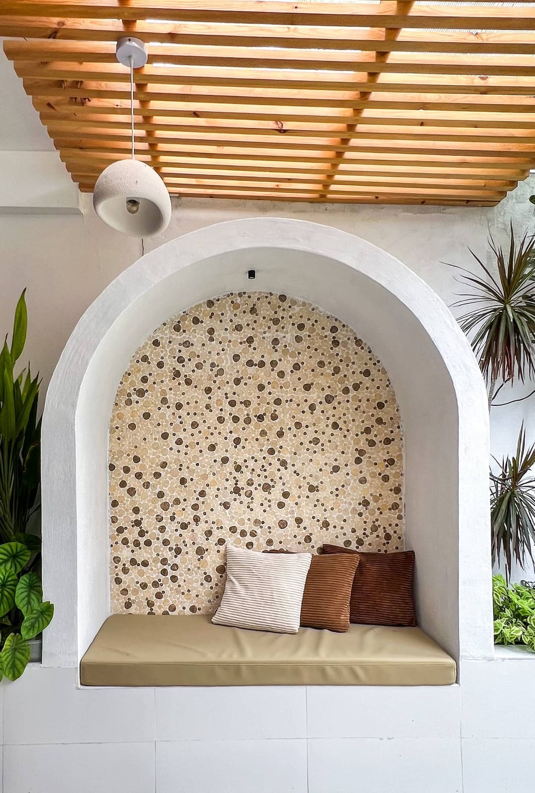 A whitewashed arch niche with joali seating at Sosun View
